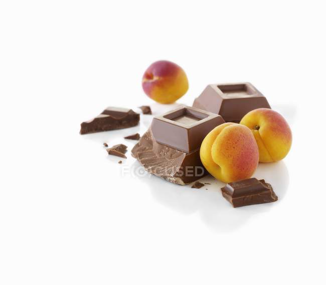 Apricots and pieces of chocolate — Stock Photo