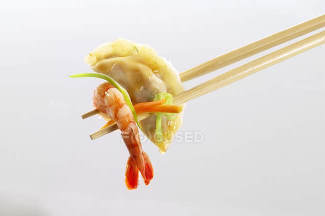 Wonton and shrimp on chopsticks — Stock Photo