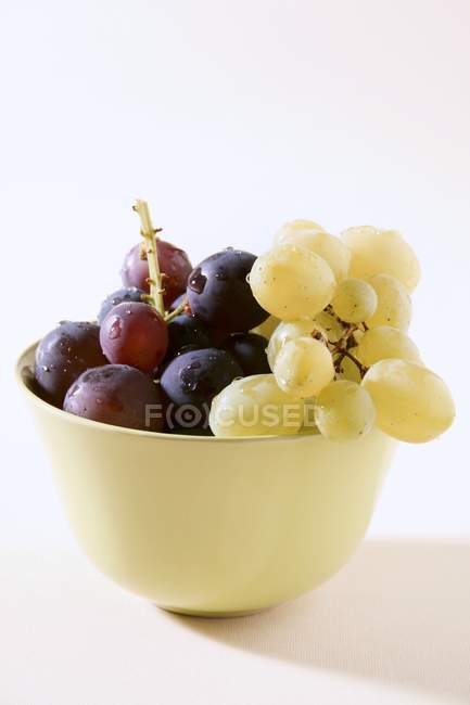 Красный и зеленый виноград в миске — стоковое фото