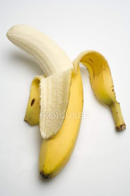 Banana fresca meio descascada — Fotografia de Stock