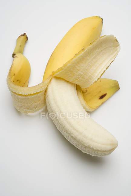 Полуочищенный свежий банан — стоковое фото