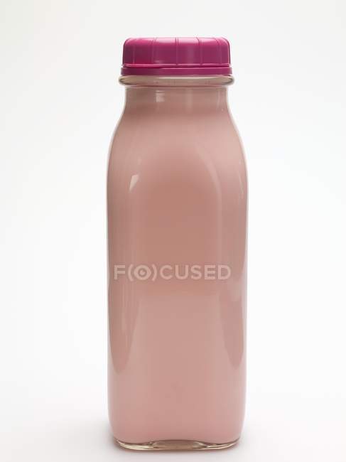Vue rapprochée de la sauce rose en bouteille de verre sur la surface blanche — Photo de stock