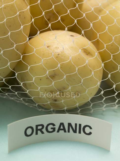 Batatas orgânicas em saco líquido — Fotografia de Stock