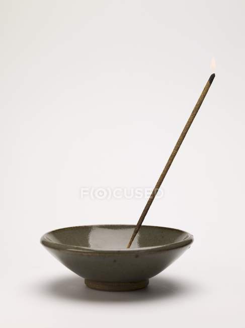 Bâton d'encens aromatique dans un plat en céramique sur surface blanche — Photo de stock
