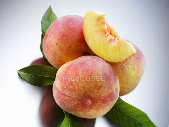 Yellow Florentine peaches with leaves — Stock Photo