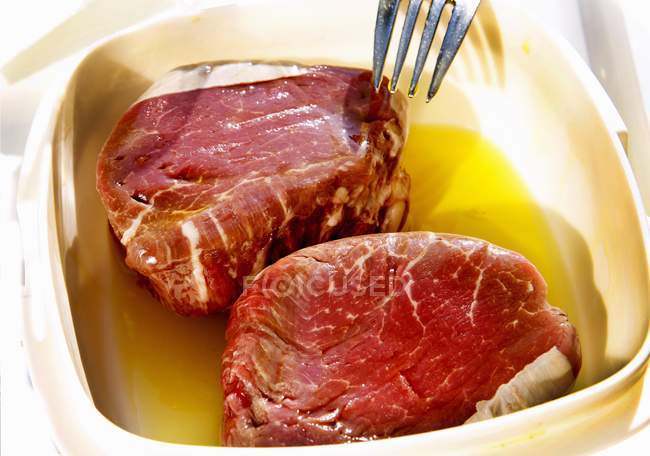 Steaks in butter marinade — Stock Photo