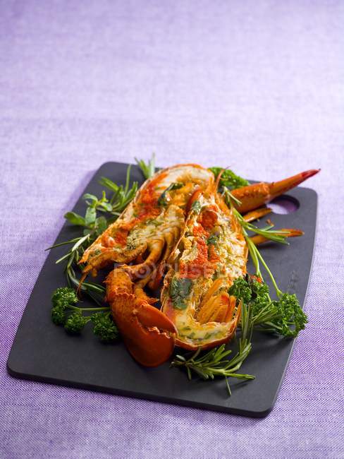 Closeup view of lobster with herbs on cutting board — Stock Photo