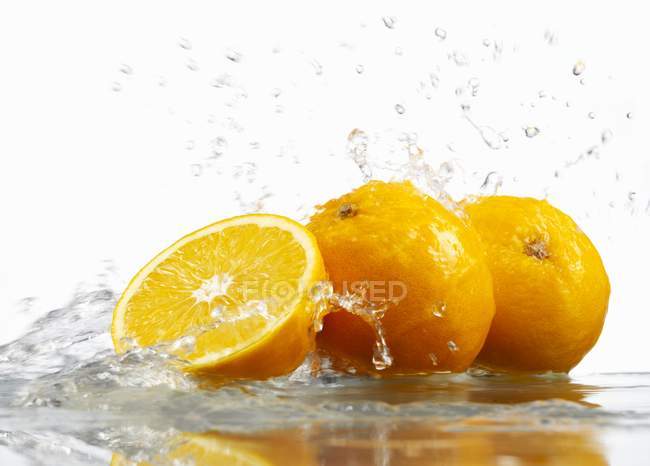 Oranges with splashing water — Stock Photo