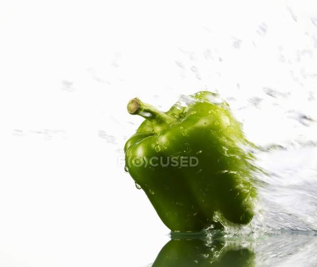 Pimienta verde con agua salpicada - foto de stock
