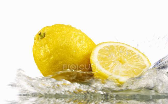 Limões com água salpicante — Fotografia de Stock
