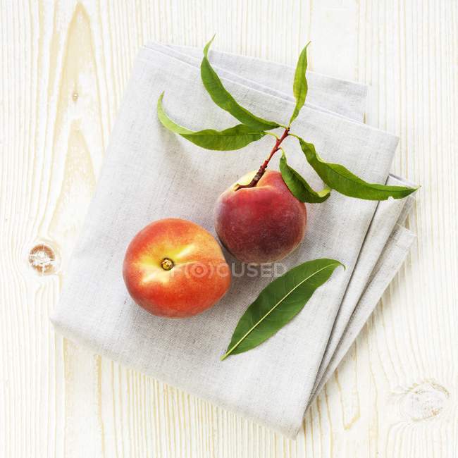 Organic peaches on linen cloth — Stock Photo