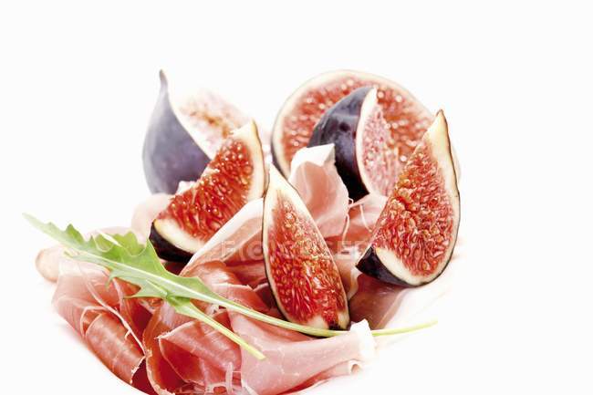 Fresh figs with Serrano ham and rocket — Stock Photo