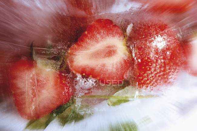 Strawberries and cherries in ice block — Stock Photo