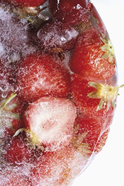 Strawberries and cherries in ice block — Stock Photo