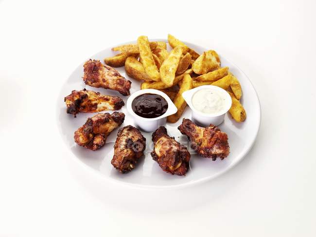 Barbecue chicken wings with potato wedges — Stock Photo