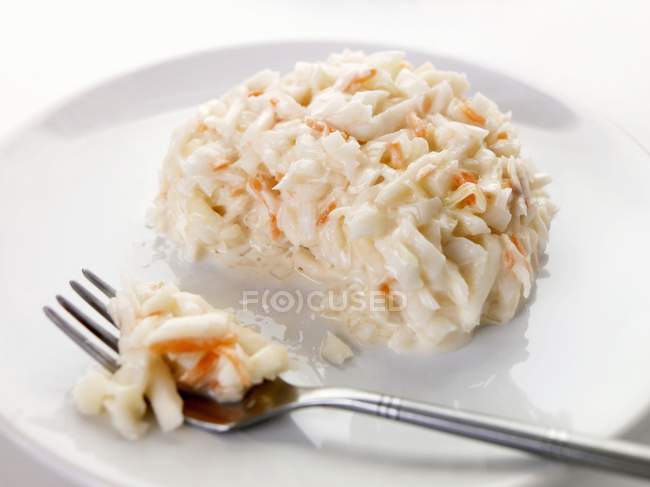 Капустный салат на белой тарелке с вилкой — стоковое фото