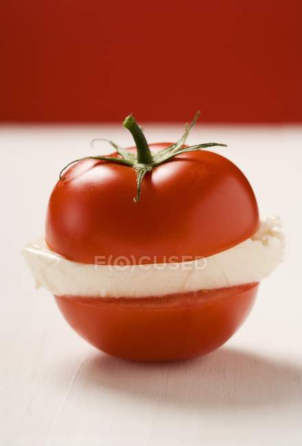 Tomato with slice of mozzarella — Stock Photo