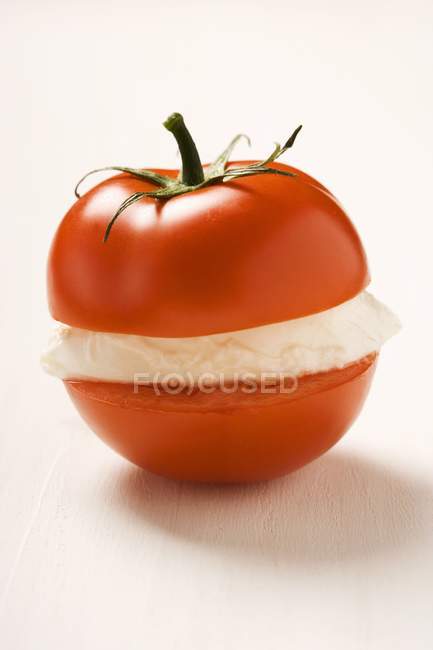 Tomato with slice of mozzarella — Stock Photo