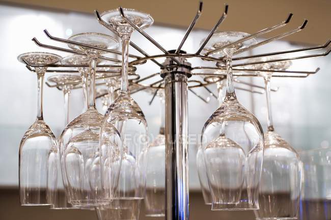 Closeup view of Champagne and wine glasses hanging upside down in a restaurant shelf — Stock Photo