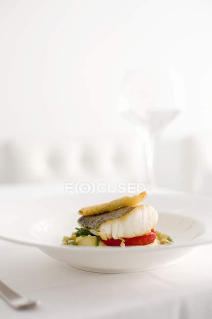 Filete de bacalao frito sobre verduras - foto de stock