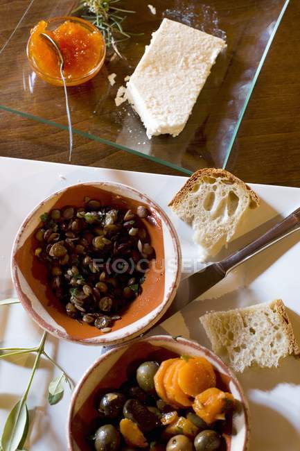 Vista superior de los aperitivos vegetales mediterráneos con pan, mantequilla y jalea - foto de stock