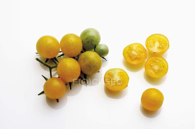 Whole and halved yellow tomatoes — Stock Photo