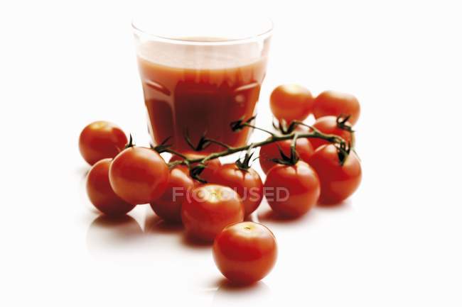 Vaso de jugo de tomate con tomates de cóctel - foto de stock