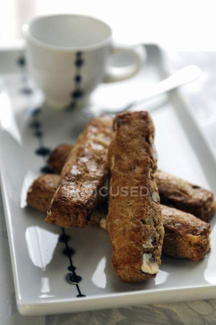 Closeup view of Cantuccini sweets on platter with cup and spoon — Stock Photo