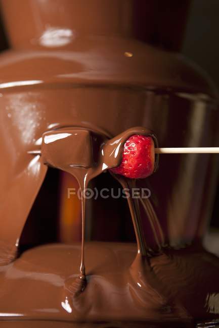 Closeup view of chocolate sauce with strawberry on toothpick — Stock Photo
