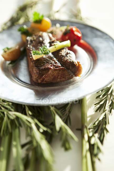 Steak sur assiette au-dessus des herbes — Photo de stock