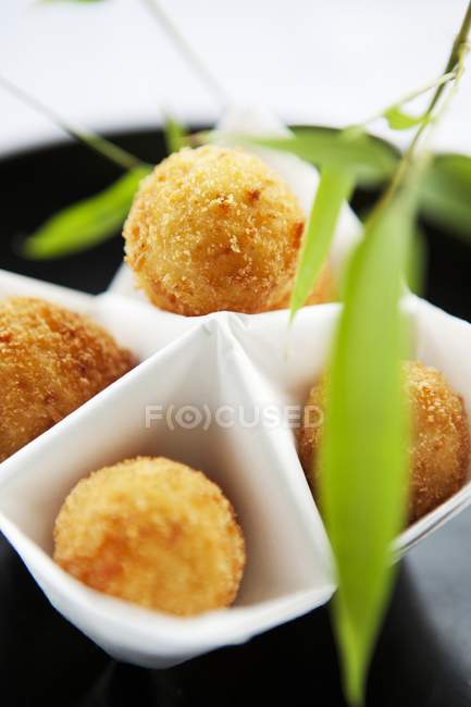 Closeup view of fried balls in white dish with leaves — Stock Photo