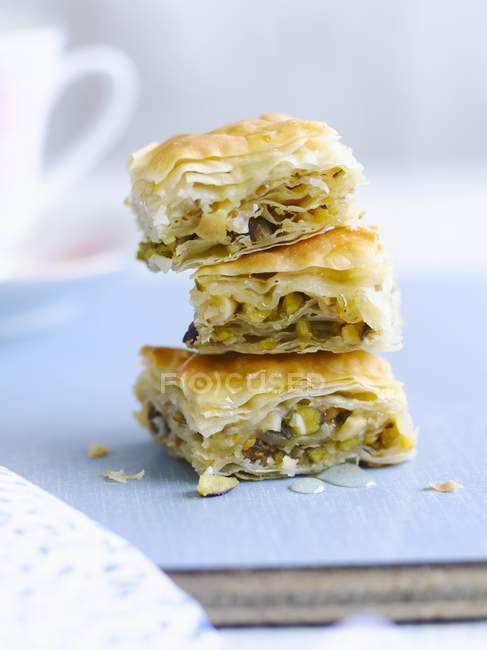 Closeup view of stacked baklava pieces on blue surface — Stock Photo