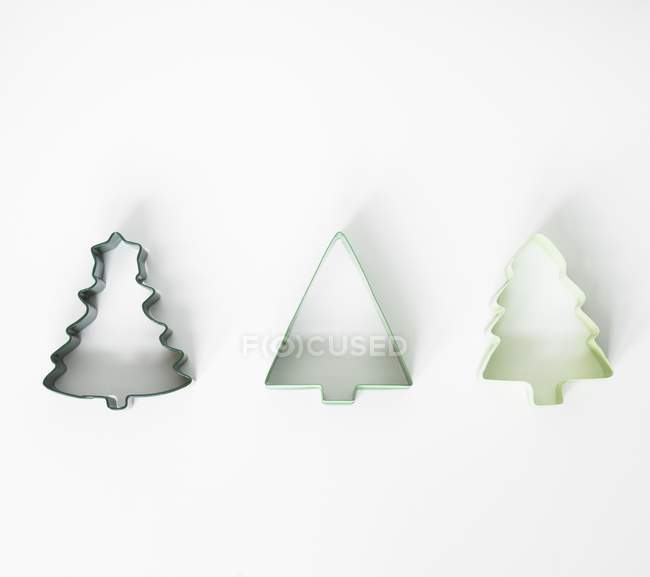 Closeup view of three different shaped tree cookie cutters on white surface — Stock Photo