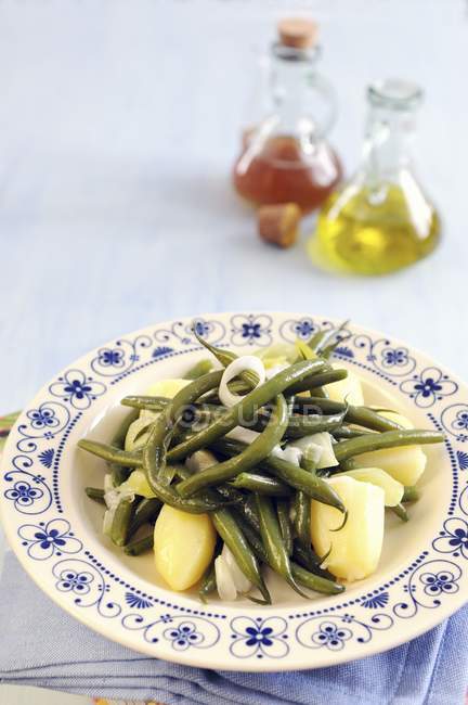 Green beans with potatoes and sauteed spring onions on plate — Stock Photo