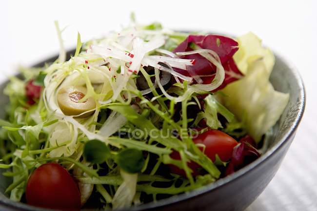 Змішаний салат у чорній мисці — стокове фото