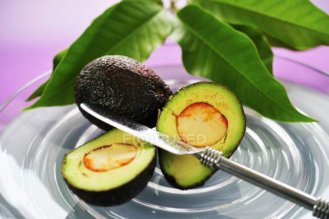 Целый и наполовину авокадо — стоковое фото
