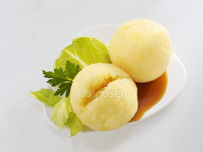 Potato dumplings with gravy on white plate over white background — Stock Photo