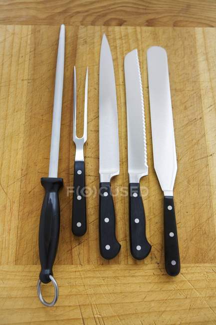 Elevated view of assorted kitchen knives with carving fork and sharpening steel — Stock Photo