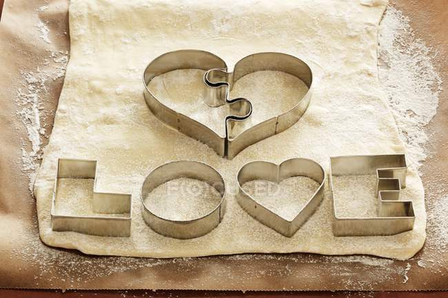 Closeup view of biscuit cutters for Love biscuits on dough — Stock Photo