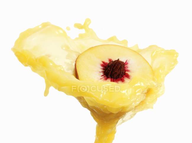 Halber Pfirsich mit Spritzer — Stockfoto