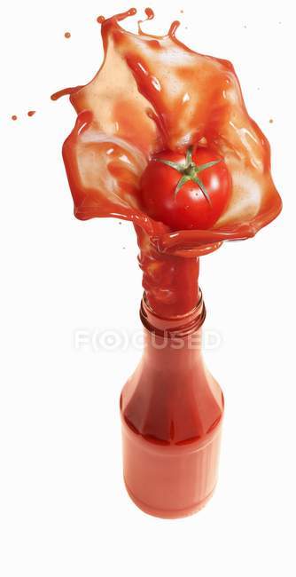 Tomato ketchup splashing out of bottle — Stock Photo