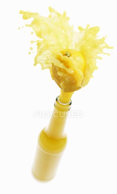 Zitronensaft spritzt aus Flasche — Stockfoto