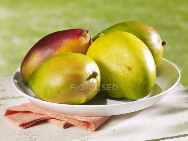 Fresh mangos on plate — Stock Photo