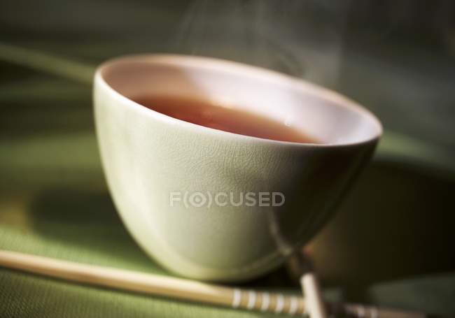 Чашка чая и палочки для еды — стоковое фото