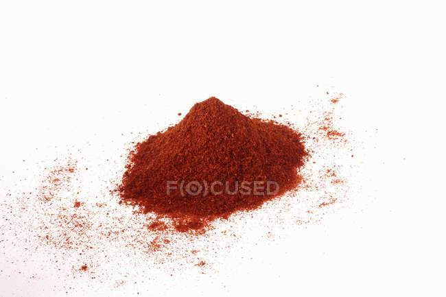 Closeup view of chilli powder heap on white surface — Stock Photo