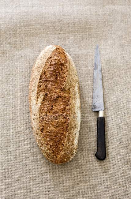 Pão e faca sobre têxteis — Fotografia de Stock