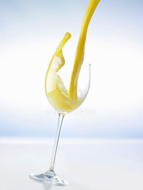 Verser le jus d'orange dans le verre — Photo de stock