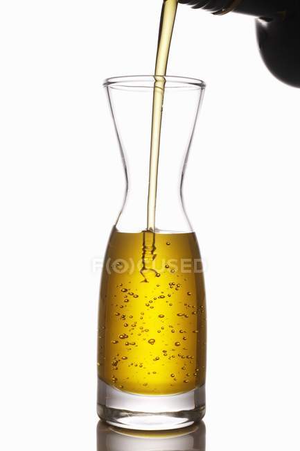Olivenöl in eine Karaffe gießen — Stockfoto