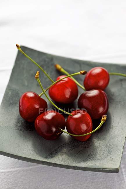 Свежие вишни в квадратной тарелке — стоковое фото