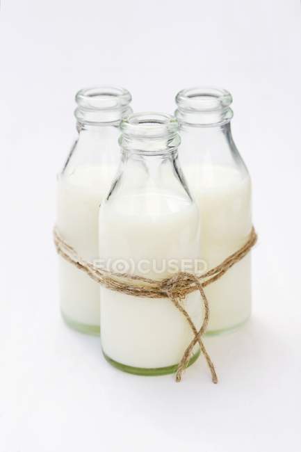 Closeup view of three bottles of cream tied with a string — Stock Photo